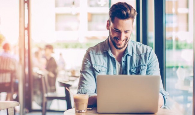 Vibrant community life with a variety of dining options a man sitting at a  cafe table with a laptop
