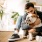 man sits in his living room and hugs his dog