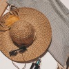 sun glasses, hat and sunscreen laid out on a lounge chair with a towel